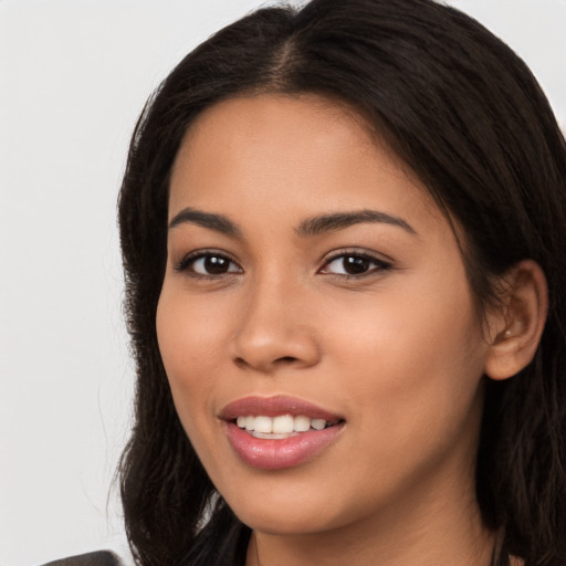 Joyful latino young-adult female with long  brown hair and brown eyes