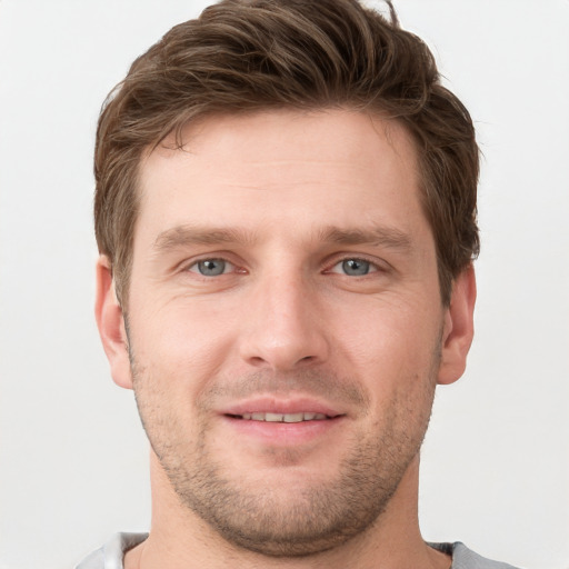 Joyful white young-adult male with short  brown hair and grey eyes