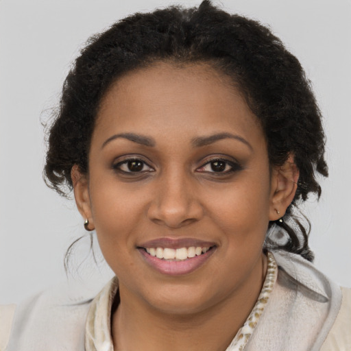 Joyful black young-adult female with short  brown hair and brown eyes