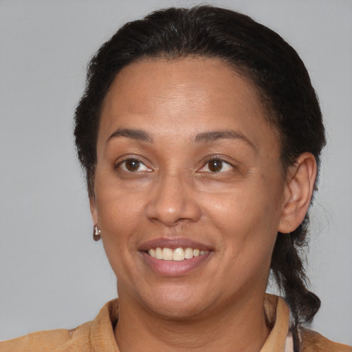 Joyful black adult female with medium  brown hair and brown eyes