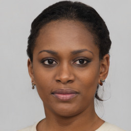 Joyful black young-adult female with short  black hair and brown eyes