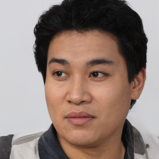 Joyful asian young-adult male with short  black hair and brown eyes