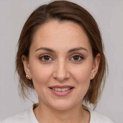 Joyful white young-adult female with medium  brown hair and brown eyes