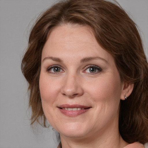 Joyful white adult female with medium  brown hair and grey eyes