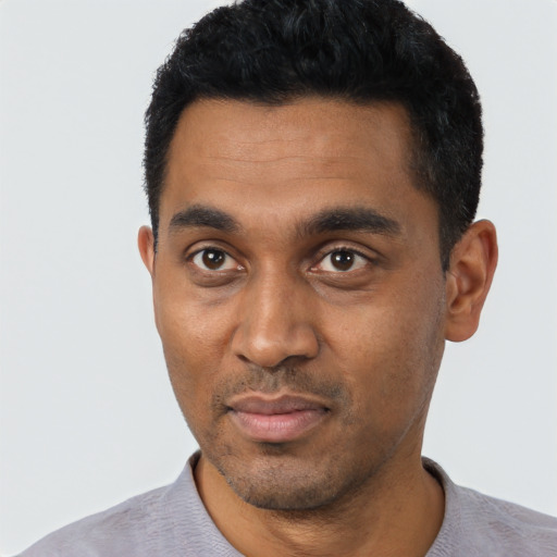 Joyful black young-adult male with short  black hair and brown eyes