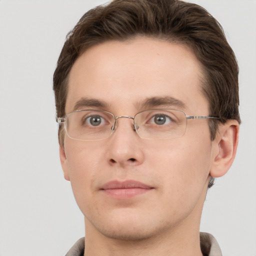 Joyful white young-adult male with short  brown hair and grey eyes