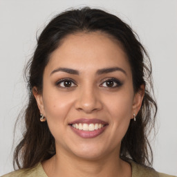 Joyful latino young-adult female with long  brown hair and brown eyes