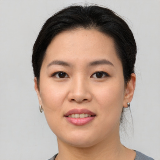 Joyful asian young-adult female with short  black hair and brown eyes