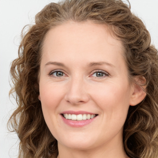 Joyful white young-adult female with long  brown hair and green eyes