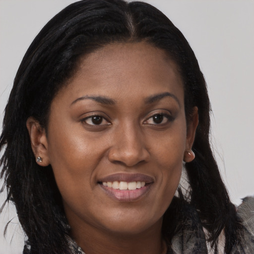 Joyful black young-adult female with long  brown hair and brown eyes