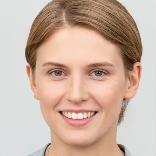 Joyful white young-adult female with short  brown hair and grey eyes