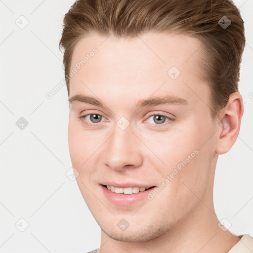 Joyful white young-adult male with short  brown hair and grey eyes