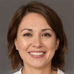 Joyful white adult female with medium  brown hair and brown eyes