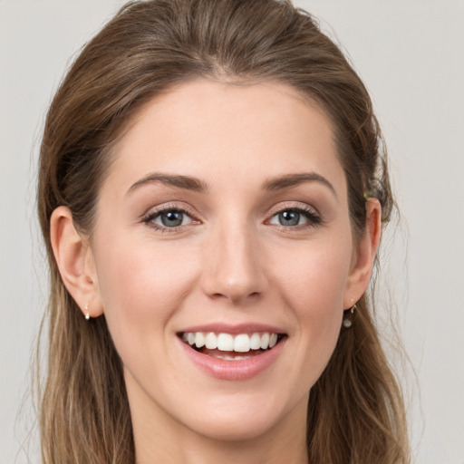 Joyful white young-adult female with long  brown hair and grey eyes