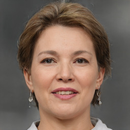 Joyful white adult female with medium  brown hair and grey eyes