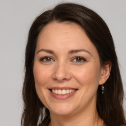 Joyful white adult female with long  brown hair and brown eyes