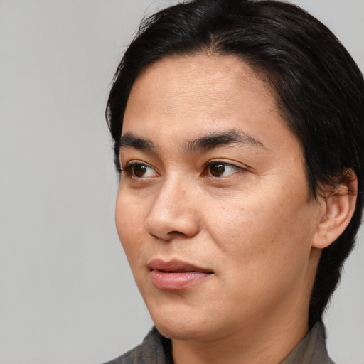 Joyful asian young-adult male with medium  black hair and brown eyes