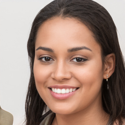 Joyful latino young-adult female with long  brown hair and brown eyes