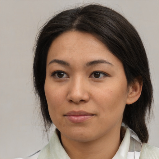 Joyful asian young-adult female with medium  brown hair and brown eyes