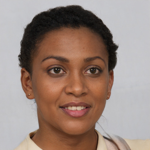 Joyful black young-adult female with short  brown hair and brown eyes
