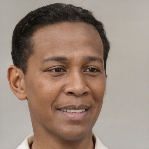 Joyful latino young-adult male with short  brown hair and brown eyes