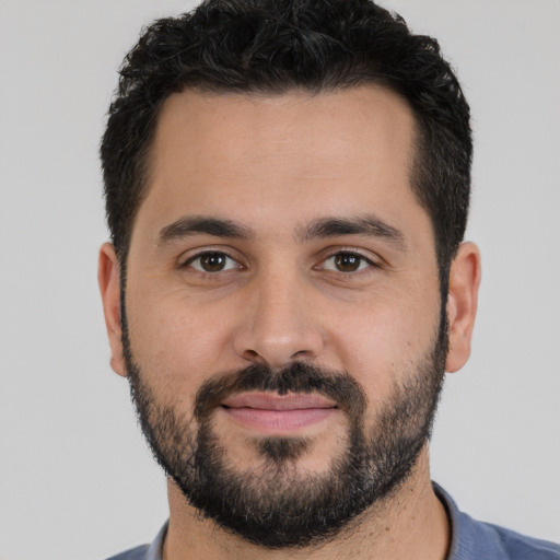 Joyful white young-adult male with short  black hair and brown eyes