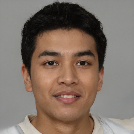 Joyful latino young-adult male with short  brown hair and brown eyes
