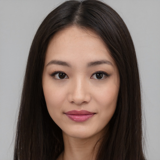 Joyful asian young-adult female with long  brown hair and brown eyes