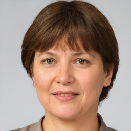 Joyful white adult female with medium  brown hair and grey eyes