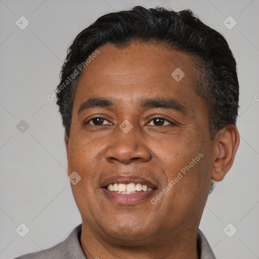 Joyful latino adult male with short  black hair and brown eyes
