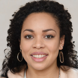 Joyful black young-adult female with long  brown hair and brown eyes