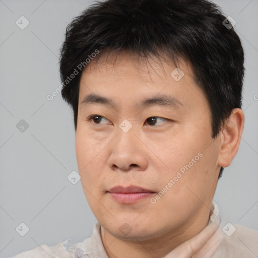 Joyful asian young-adult male with short  brown hair and brown eyes