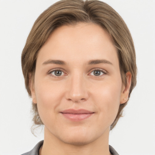 Joyful white young-adult female with medium  brown hair and grey eyes