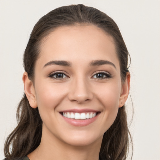 Joyful white young-adult female with long  brown hair and grey eyes