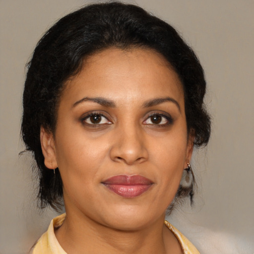 Joyful black adult female with medium  brown hair and brown eyes