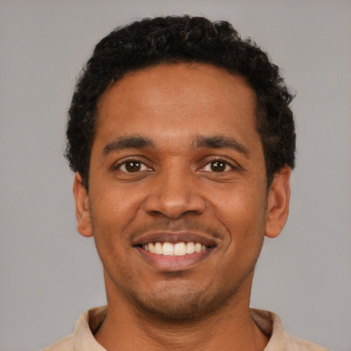 Joyful black young-adult male with short  black hair and brown eyes