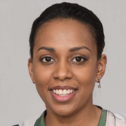 Joyful black young-adult female with short  black hair and brown eyes