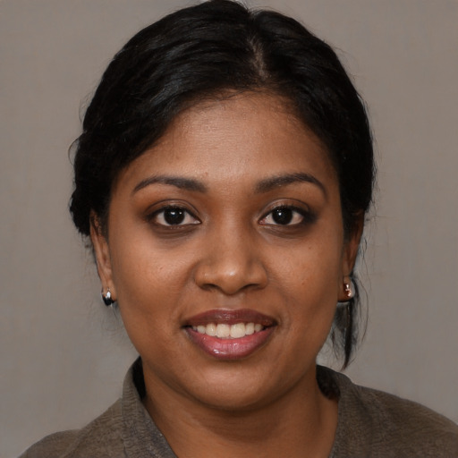 Joyful black young-adult female with medium  black hair and brown eyes