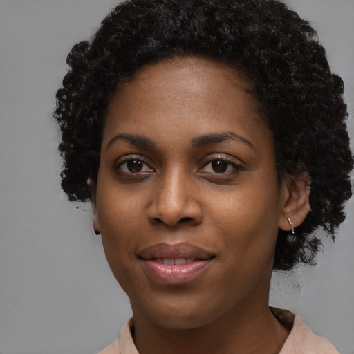 Joyful black young-adult female with short  black hair and brown eyes