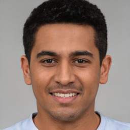 Joyful latino young-adult male with short  black hair and brown eyes