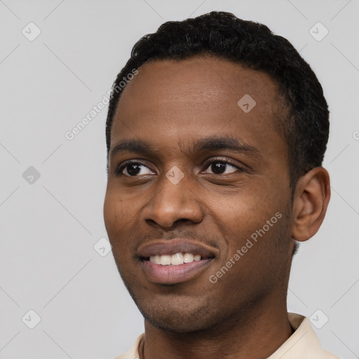 Joyful black young-adult male with short  black hair and brown eyes