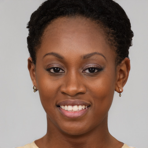 Joyful black young-adult female with short  brown hair and brown eyes