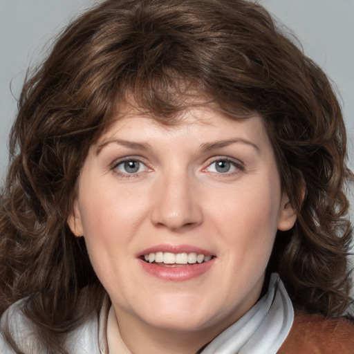 Joyful white young-adult female with medium  brown hair and blue eyes