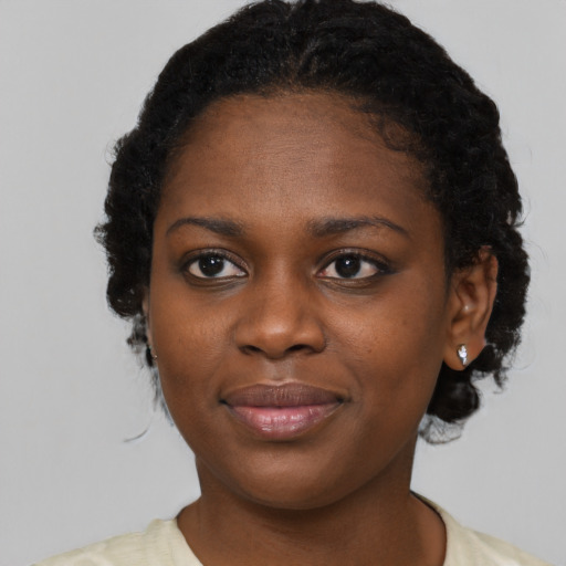 Joyful black young-adult female with short  brown hair and brown eyes