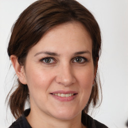 Joyful white young-adult female with medium  brown hair and grey eyes