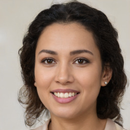 Joyful latino young-adult female with medium  brown hair and brown eyes