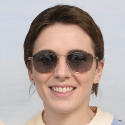 Joyful white young-adult female with medium  brown hair and blue eyes