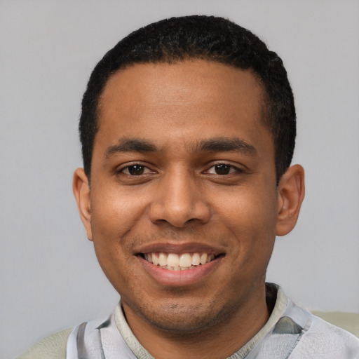 Joyful latino young-adult male with short  black hair and brown eyes