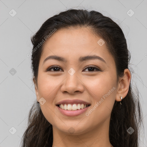 Joyful latino young-adult female with long  brown hair and brown eyes