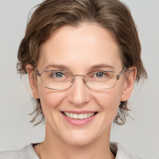 Joyful white adult female with medium  brown hair and grey eyes